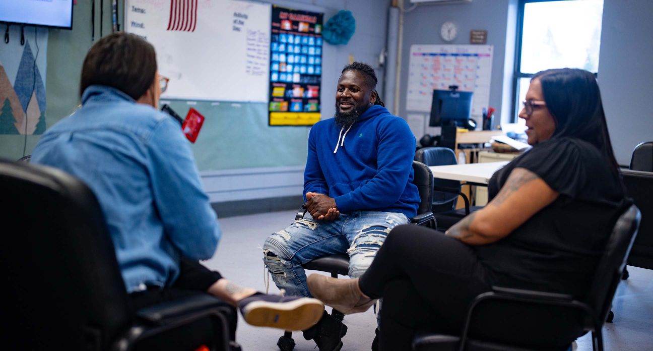 Man talking on a classroom to two people