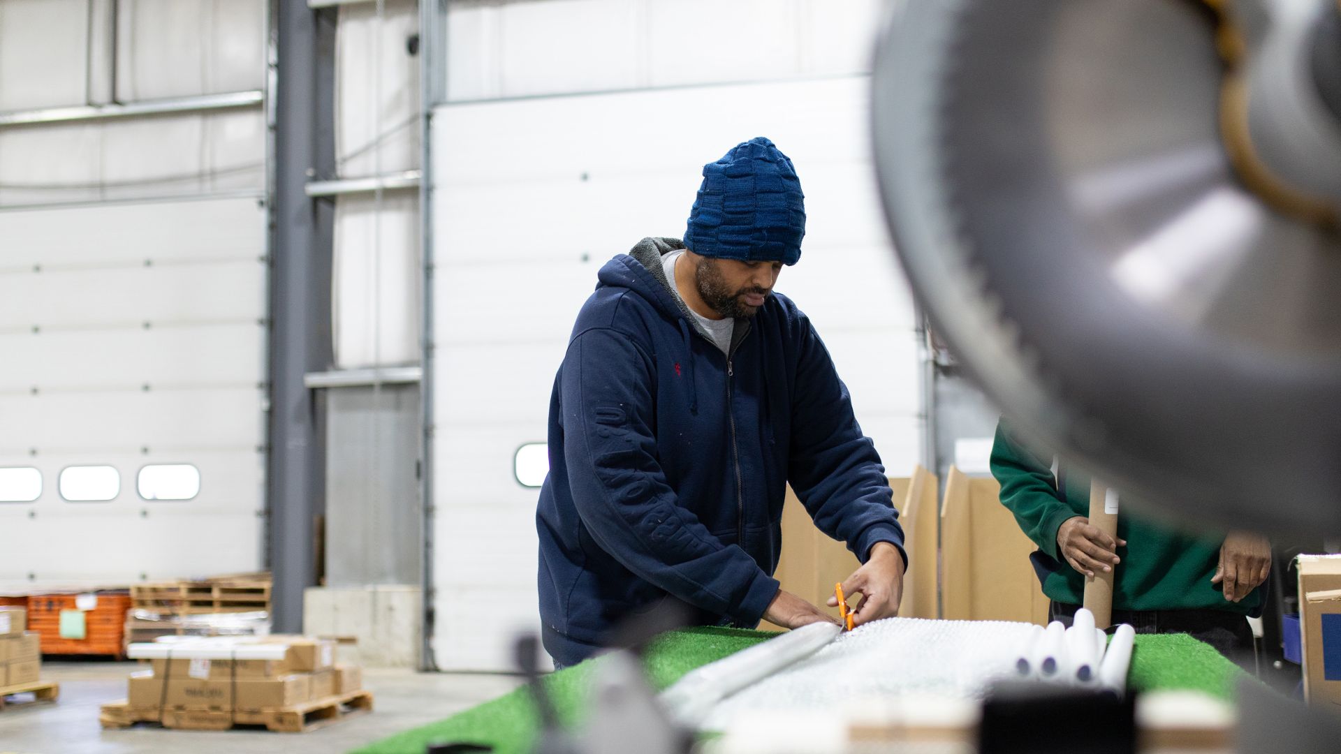 Man cutting fabric in a factory setting